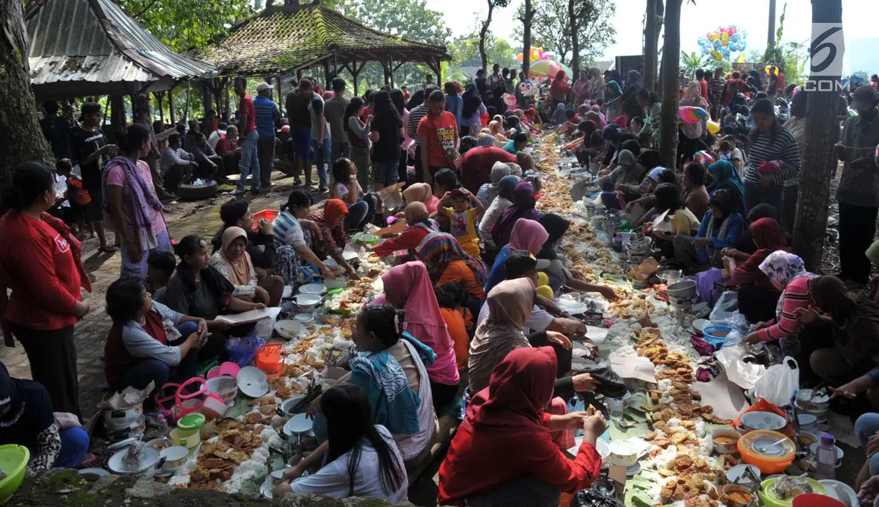Warga mengikuti prosesi bancakan atau makan bersama dalam tradisi Sadranan di Sendang Gede Pucung, Pudakpayung, Semarang, Jumat (12/4). Tradisi turun temurun membersihkan mata air dilanjutkan berdoa dan makan bersama itu sebagai rasa syukur warga setempat atas limpahan rezeki. (Liputan6.com/Gholib)
