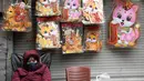 Foto yang diambil pada 17 Januari 2023 ini menunjukkan seorang penjaga toko menunggu pelanggan untuk menjual dekorasi kucing di pasar di kawasan lama Hanoi, menjelang tahun baru Imlek. Selain itu, memelihara kelinci juga tidak umum di Vietnam. Yang jelas, masyarakat Vietnam tidak mau mengubah tradisi mereka. (Nhac NGUYEN / AFP)