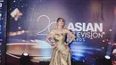 Gaun tersebut memiliki detail drapery yang rumit memberikan kesan mewah dan elegan. Gaunnya dipadukan dengan beberapa aksesoris emas seperti gelang dan anting besar yang mewah. @revashion, selaku fashion stylist, berhasil mengkurasi gaya yang menonjolkan pesona Luna dengan sempurna.  [@styledbyrevashion/@lunamaya].