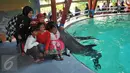 Pengunjung mendapat ciuman dari lumba-lumba saat Atraksi Dolphin Christmas Show di Ocean  Dream Samudera Ancol, Jakarta, Jumat (25/15/2015). Pertunjukan tersebut diadakan dalam rangka menyambut libur Natal. (Liputan6.com/Gempur M Surya)