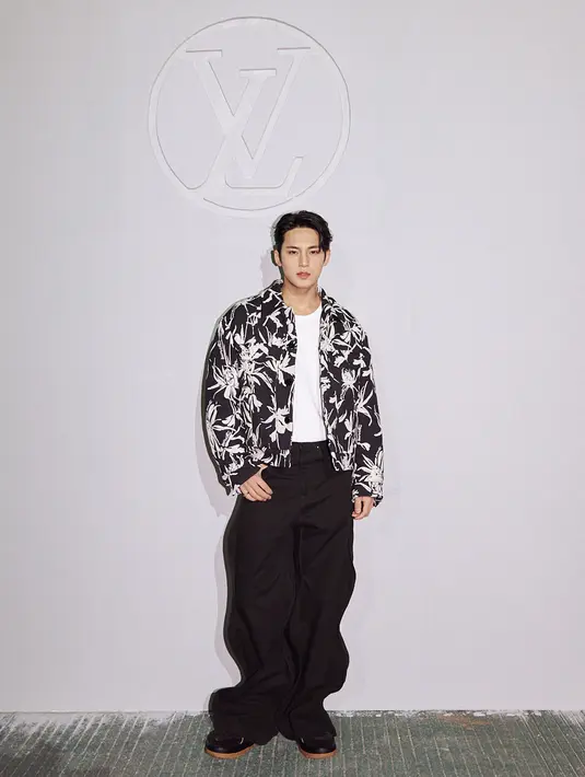 Mingyu Seventeen tampil monokrom dengan jaket floral, inner putih, dan trousers pants warna hitam.  [Foto: Louis Vuitton].