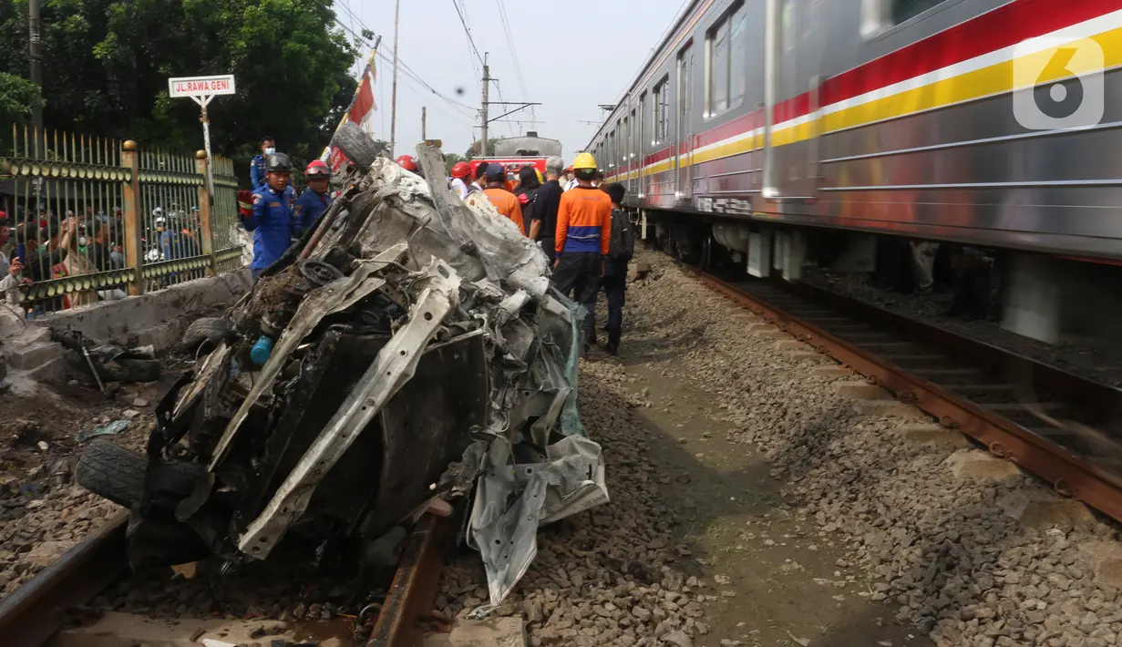 Kereta melintas di samping mobil Honda Mobilio yang tertabrak KRL Commuterline KA 1077 (Bogor-Jakarta Kota) di kawasan Rawageni, Ratu Jaya, Cipayung, Depok, Jawa Barat, Rabu (20/4/2022). Terganggunya perjalanan KRL karena kereta harus melaju di satu jalur secara bergantian. (merdeka.com/Arie Basuki)