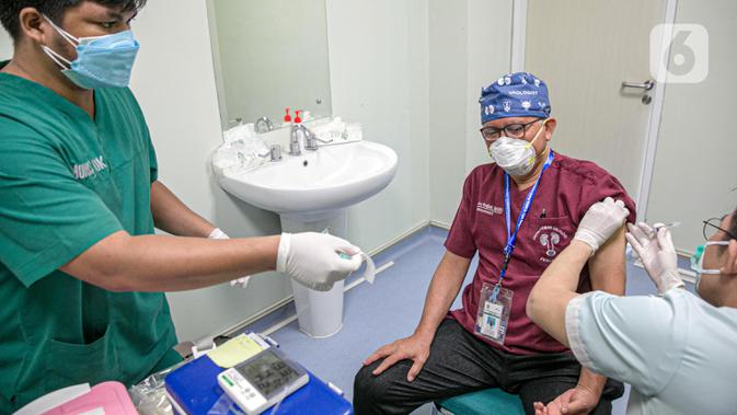Vaksinator menyuntikkan vaksin COVID-19 produksi Sinovac kepada tenaga kesehatan saat kegiatan vaksinasi di RSCM di Jakarta, Senin (8/2/2021). Kementerian Kesehatan secara resmi memulai vaksinasi tenaga kesehatan di atas 60 tahun pada hari ini. (Liputan6.com/Faizal Fanani)