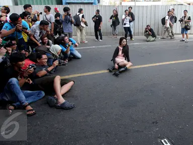 Para fotografer melakukan pemotretan seorang model di Jalan MH Thamrin, Jakarta, Minggu (19/7/2015). Momen Jakarta sepi akibat banyak yang mudik, dimanfaatkan fotografer untuk memotret model. (Liputan6.com/Johan Tallo)