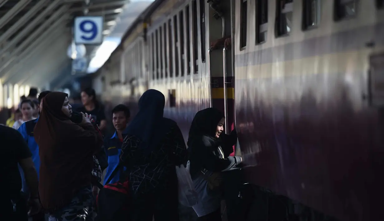 Seorang wanita menaiki kereta untuk pulang ke kampung halamannya di stasiun kereta api Hua Lampong, sehari sebelum Songkran Festival, atau Tahun Baru Thailand, di Bangkok (12/4). (AFP Photo/Lillian Suwanrumpha)