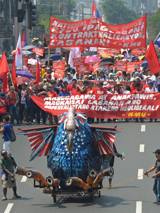 Serikat buruh Filipina membawa patung raksasa saat unjuk rasa May Day di Manila, Senin (1/5). Pekerja di berbagai belahan dunia mengadakan aksi Hari Buruh Internasional dengan memadati jalan-jalan besar menyuarakan aspirasi. (TED ALJIBE/AFP)