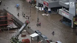 Pengendara sepeda motor mendorong kendaraannya akibat banjir di Jalan Boulevard Barat Raya, Kelapa Gading, Jakarta Utara, Kamis (15/2). Hujan lebat mengakibatkan kawasan tersebut kebanjiran. (Liputan6.com/Arya Manggala)