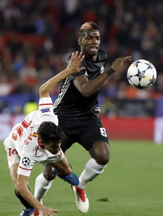 Aksi pemain Manchester United, Paul Pogba (kanan) saat berebut bola dengan pemain Sevilla, Jesus Navas pada laga 16 besar Liga Champions di Ramon Sanchez Pizjuan stadium, Seville, (21/2/2018). Babak kedua Sevilla bermain imbang 0-0. (AP/Miguel Morenatti)