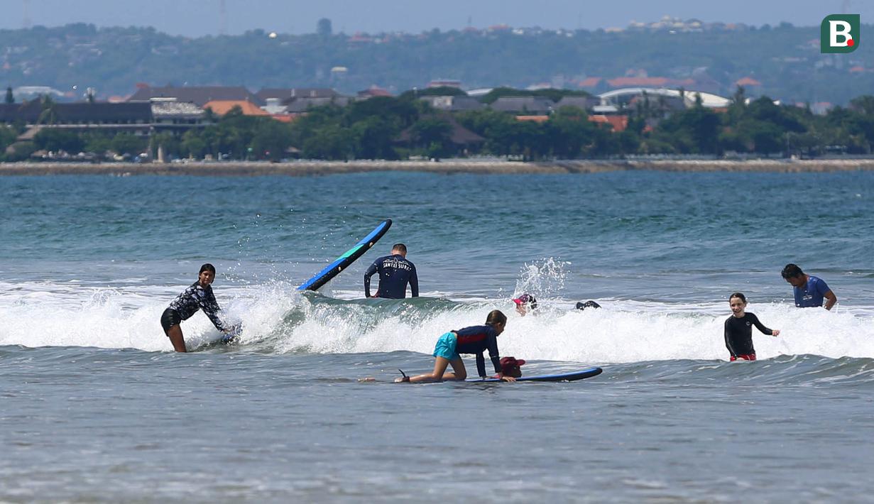 Untuk para pemula atau wisatawan yang ingin belajar bermain surfing, kini warga lokal juga menyediakan jasa penyewaan papan selancar sekaligus pendamping. (Bola.com/M iqbal Ichsan)