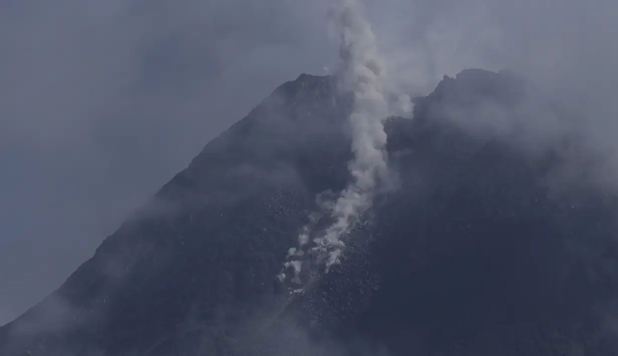 Gunung Merapi memuntahkan material vulkanik dari kawahnya seperti yang terlihat dari Sleman, Yogyakarta (7/1/2021). Teramati asap kawah utama berwarna putih dengan intensitas sedang hingga tebal, tinggi asap sekitar 20-100 meter dari puncak. (AP Photo/Slamet Riyadi)