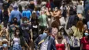 Orang-orang yang memakai masker berjalan di sepanjang jalan di Madrid, Spanyol, Kamis (24/6/2021). Spanyol melonggarkan aturan pandemi COVID-19, mengizinkan orang berhenti mengenakan masker di luar ruangan dan mengizinkan penggemar olahraga kembali ke dalam stadion.  (AP Photo/Manu Fernandez)