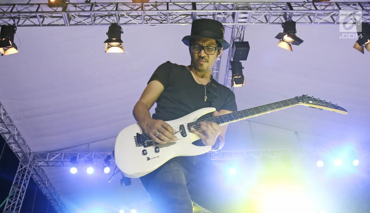 Aksi gitaris Slank, Ridho di atas panggung konser perayaan HUT ke-34 Slank di JIExpo Kemayoran, Jakarta, Selasa (26/12). Ada sekitar 20 lagu yang dibawakan oleh band yang berdiri sejak 26 Desember 1983 tersebut. (Liputan6.com/Herman Zakharia)