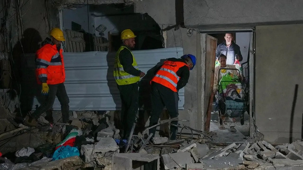 Warga membawa barang-barang pribadi saat meninggalkan sebuah bangunan yang rusak akibat serangan rudal di Tel Aviv, Israel, Sabtu (28/3/2026) dini hari.