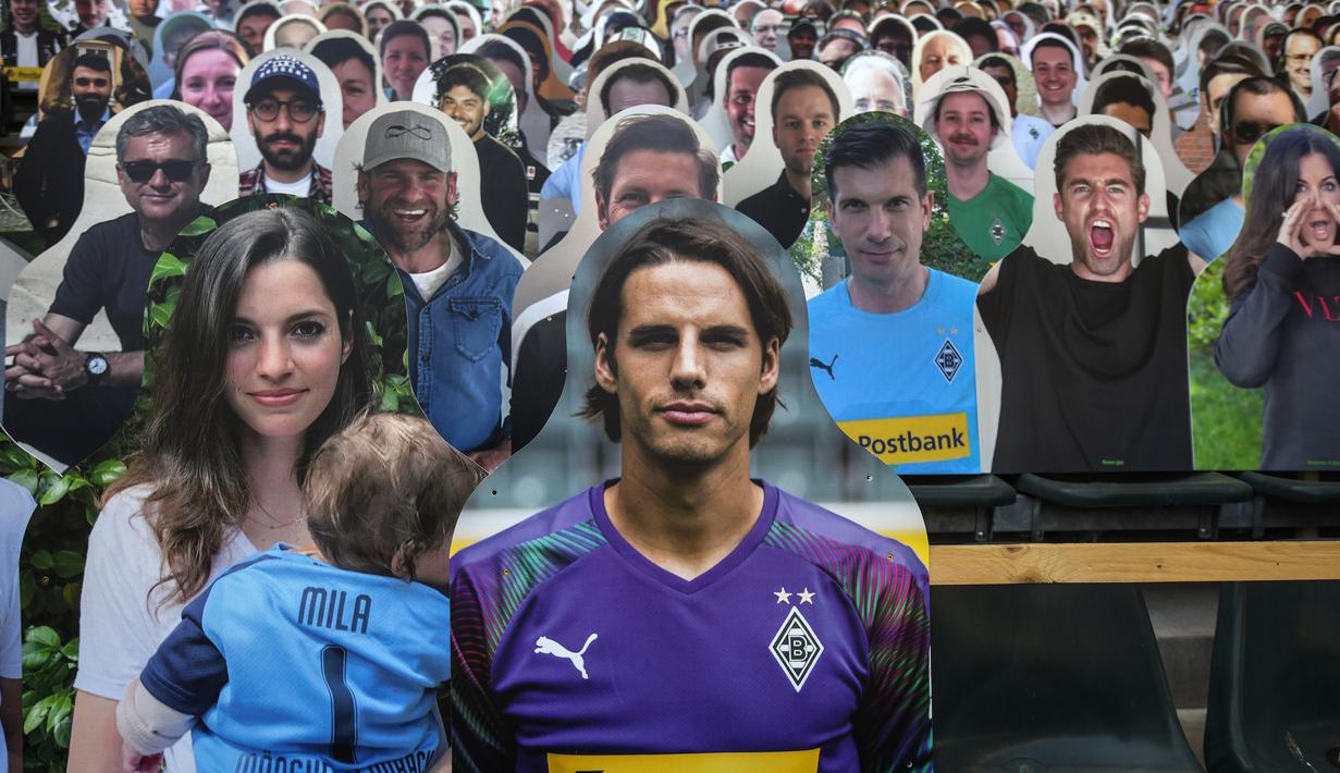 Cardboard pendukung Borussia Moenchegladbach mengisi kursi penonton di stadion Borussia Park, Moenchengladbach, Jerman, Rabu (20/5/2020). Ribuan Cardboard gambar suporter Borussia Moenchegladbach dipasang untuk mendukung timnya saat berlaga di kompetisi Bundesliga. (AFP/Ina Fassbender)