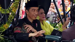 Presiden Joko Widodo bersama Ibu Negara Iriana menyapa warga saat kirab resepsi pernikahan Kahiyang Ayu-Bobby Nasution di Kota Medan, Sumatera Utara, Minggu (26/11). (Liputan6.com/Johan Tallo)