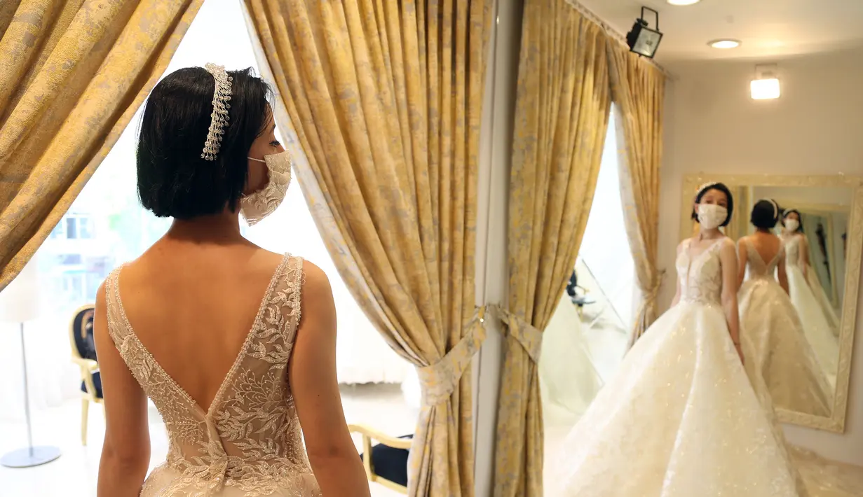 Seorang pelanggan mencoba gaun pengantin yang dirancang khusus dengan masker di Ankara, Turki, Sabtu (6/6/2020). Hingga 6 Juni 2020, total kasus COVID-19 di Turki melonjak menjadi 169.218. (Xinhua/Mustafa Kaya)