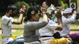 Umat Hindu Bali memperingati Hari Raya Galungan di Pura Amerta Jati, Jalan Punak, Pangkalan Jati, Cinere, Depok, Rabu (14/4/2021). Di tengah pandemi COVID-19, Pura Amerta Jati menerapkan protokol kesehatan dan pembatasan umat yang hadir untuk memperingati Galungan. (Liputan6.com/Johan Tallo)