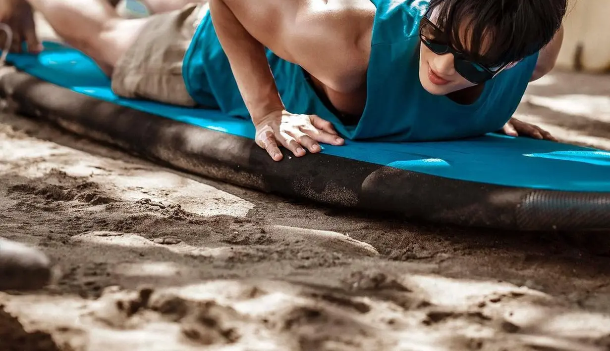 Potret Ahn Bo Hyun saat menjajal papan selancar sebelum dia benar-benar surfing di pantai lepas. Bintang serial Kairos ini memamerkan otot lengannya yang kekar. (Foto: Instagram/ bohyunahn)