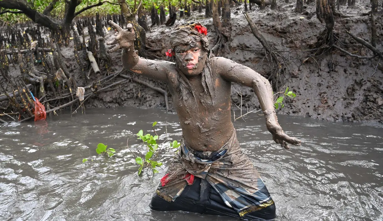 Seorang pria Bali mengambil bagian dalam tradisi mandi lumpur, yang dikenal sebagai Mebuug-buugan, di desa Kedonganan, Bali, pada 12 Maret 2024. (SONNY TUMBELAKA/AFP)