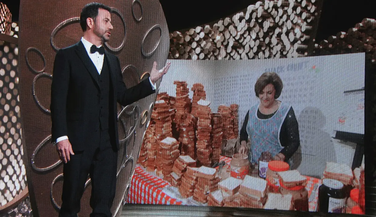 Host Jimmy Kimmel menyaksikan video saat ibunya, Joann Iacono, membuat 7.000 sandwich selai isi kacang untuk dibagikan kepada para hadirin selama penghargaan Emmy Awards 2016, di Los Angeles, Minggu (18/9). (Kevin Winter/Getty Images NORTH AMERICA/AFP)
