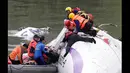 Petugas penyelamat menarik penumpang yang terjebak dalam badan pesawat yang tenggelam di Sungai Taipei, Taiwan, Rabu (4/2/2015). Dilaporkan 3 orang tewas dan puluhan lainnya terjebak. (REUTERS/Pichi Chuang)