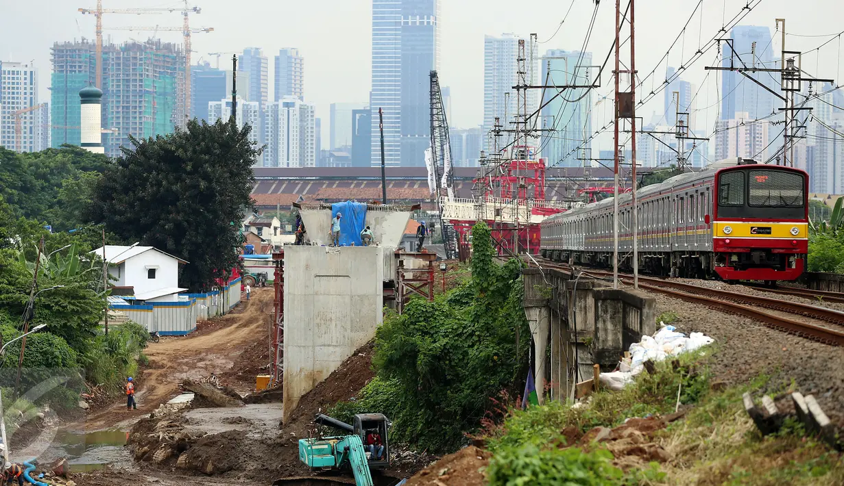 Kereta melintas di dekat pembangunan proyek double-double track (DDT) Paket A Manggarai-Jatinegara, Jakarta (3/3). Proses pengerjaan Paket A jalur Manggarai-Jatinegara terus di kebut sehingga ditargetkan selesai tahun 2019. (Liputan6.com/Johan Tallo)