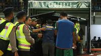 Bonek melemparkan botol dan benda tumpul ke bench setelah Persebaya Surabaya kalah 3-4 dari Persib Bandung di Stadion Gelora Bung Tomo, Surabaya, Kamis (26/7/2018). (Bola.com/Aditya Wany)