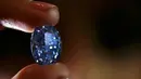 Seorang petugas memegang berlian biru 10,10 karat di rumah lelang sothbey, London, Inggris, Selasa (15/3). Diperkirakan harga berlian ini mencapai $ 35.000.000 atau 525 Miliar rupiah.  (REUTERS / Stefan Wermuth)