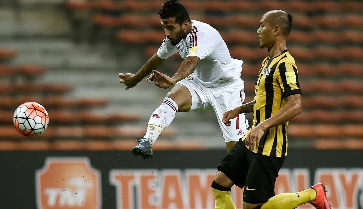 Pemain Malaysia, Ronny bin Harun (kanan), berusaha menahan tendangan pemain UEA, Ali Ahmed Makhbout, dalam Kualifikasi Piala Dunia 2018 di Stadion Shah Alam, Malaysia, (17/11/2015). Malaysia kalah 1-2 dari UEA. (AFP Photo/Manan Vatsyayana)