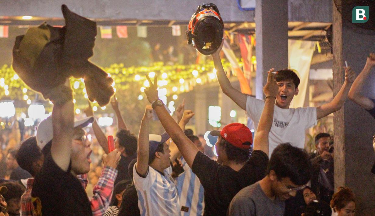 Reaksi gembira pendukung Argentina saat nobar laga final Piala Dunia 2022 bersama Federal Oil yang berlangsung di daerah Kemang, Jakarta Selatan, Minggu (18/12/2022) malam WIB. Argentina berhasil mengalahkan Prancis melalui babak penalti dengan skor 4-2. (Bola.com/Muhammad Aldiansyah)