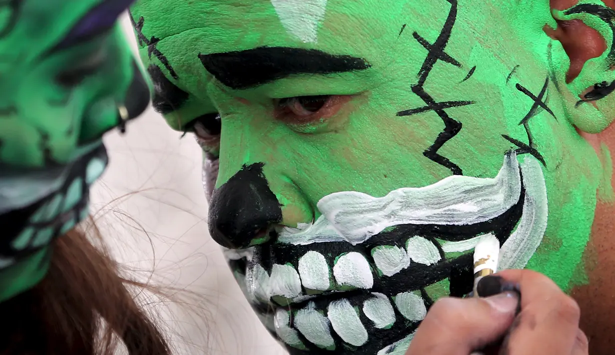 Seorang peserta menggunakan riasan zombie saat mengikuti parade "Zombie Walk" di Sao Paulo, Brasil, Senin (2/11/2015). (REUTERS / Paulo Whitaker)