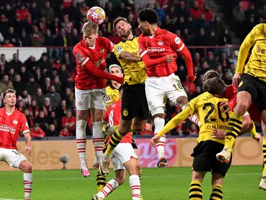 Gelandang PSV Eindhoven, Jerdy Schouten (kedua kiri) bersama Malik Tillman melompat untuk merebut bola dari pemain depan Dortmund Niclas Fuellkrug (tengah) saat pertandingan sepak bola leg pertama babak 16 besar Liga Champions melawan Borussia Dortmund di Stadion Philips, Eindhoven, 20 Februari 2024. (JOHN THYS/AFP)