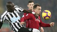 Gelandang Liverpool, Xherdan Shaqiri, berusaha melewati bek Newcastle, Mohamed Diame, pada laga Premier League di Stadion Anfield, Liverpool, Rabu (26/12). Liverpool menang 4-0 atas Newcastle. (AP/Jon Super)