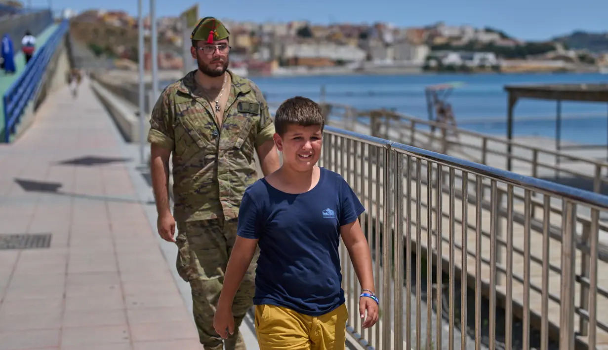 Seorang anak berusia 12 tahun yang menyeberang ke Spanyol tanpa pendamping menangis saat dikawal oleh seorang tentara Spanyol ke perbatasan Spanyol-Maroko dari wilayah kantong Spanyol di Ceuta, Senin, 3 Agustus 2026. (Foto AP/Bernat Armangue)