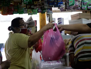 Pedagang melayani pembeli wadah dan kemasan plastik di Cipadu, Kota Tangerang, Jumat (17/9/2021). Tahun depan, pemerintah akan memutuskan untuk menerapkan cukai plastik, cukai alat makan dan minum sekali makan, serta cuka minuman manis dalam kemasan. (Liputan6.com/Angga Yuniar)