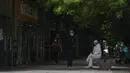 <p>Warga yang memakai masker beristirahat di dekat toko ritel yang tutup setelah perintah penutupan bisnis yang tidak penting dan meminta orang untuk bekerja di rumah di distrik Chaoyang, Beijing, Senin (9/5/2022). Jutaan orang di Beijing tinggal di rumah pada 9 Mei ketika ibu kota China mencoba untuk menangkis Covid -19 dengan pembatasan ruang gerak. (AP Photo/Andy Wong)</p>