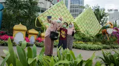 Sejumlah warga berfoto dengan dekorasi bertemakan Idul Fitri di kawasan Bundaran HI, Jakarta, Rabu (27/4/2022). Dekorasi berbentuk masjid, ketupat, dan bedug yang dihiasi oleh tanaman tersebut dalam rangka menyambut Idul Fitri 1443 Hijriah. (Liputan6.com/Faizal Fanani)