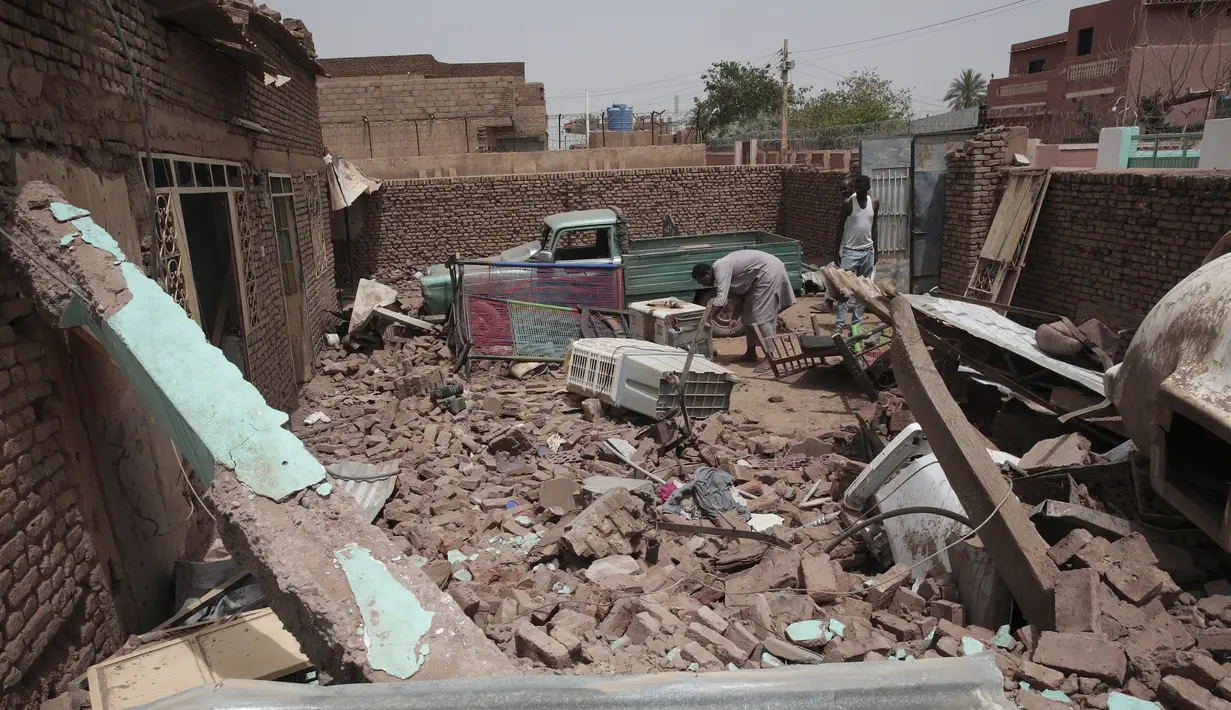 Seorang pria membersihkan puing-puing rumah yang terkena serangan dalam pertempuran baru-baru ini di Khartoum, Sudan, Selasa, 25 April 2023. (AP Photo/Marwan Ali)