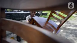 Pekerja menyelesaikan pembuatan kursi tamu ukir Jepara di Ciputat, Tangerang Selatan, Banten, Jumat (23/10/2020). Pengusaha kursi kayu jati tersebut mengatakan, pada awal pandemi COVID-19 penjualan mebel sempat turun 50 persen namun kini berangsur normal. (merdeka.com/Dwi Narwoko)