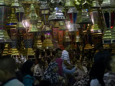 Warga berjalan melewati lampu fanus, lentera tradisional khas yang dijual selama Ramadan, di distrik Saida Zeinab di Ibu Kota Kairo, 29 Mei 2016. Masyarakat Mesir mulai memburu lampu fanus yang merupakan dekorasi khas Ramadan. (MOHAMED EL-Shahed /AFP)