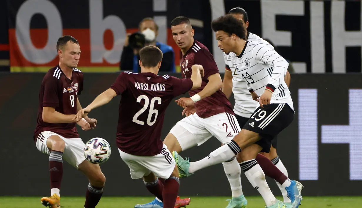 Gelandang Jerman, Leroy Sane (kanan) menguasai bola di antara tiga pemain Latvia dalam laga uji coba menjelang Euro 2020 (Euro 2021) di Merkur Spiel Arena, Duesseldorf, Senin (7/6/2021). Jerman menang 7-1 atas Latvia. (AFP/Odd Andersen)