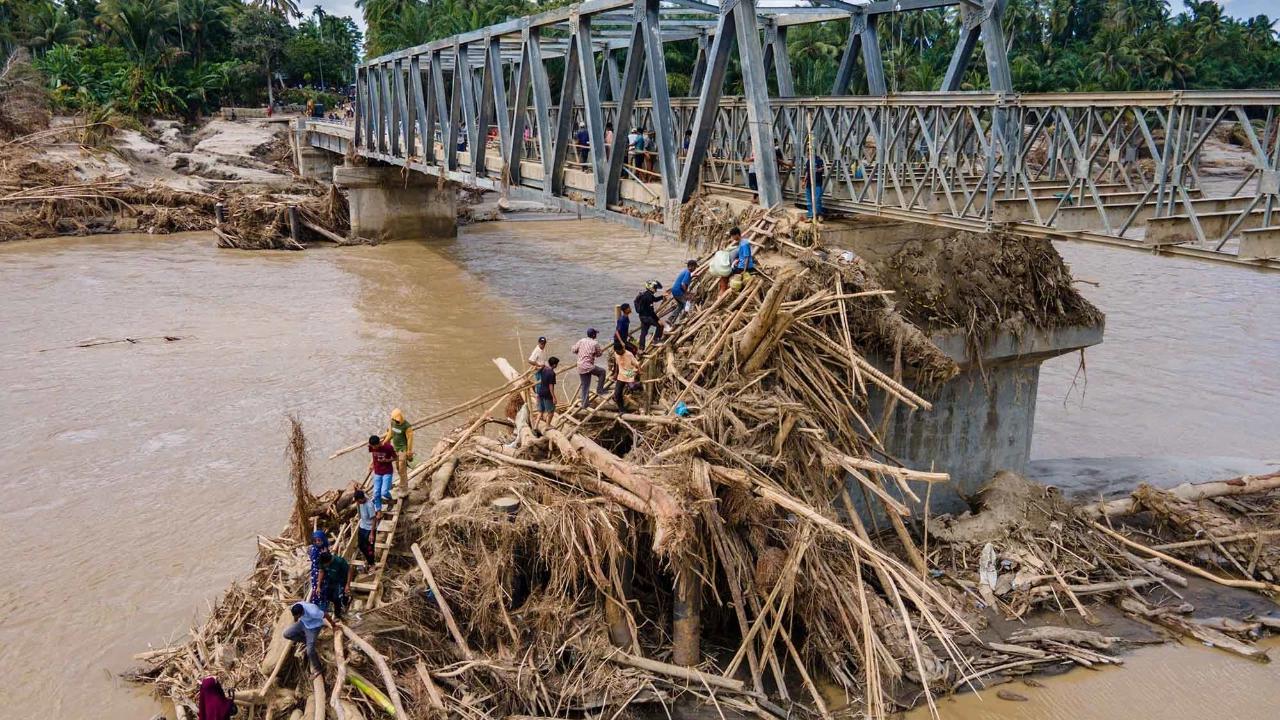FOTO: Warga Memanjat Puing Kayu Demi Menyeberangi Sungai Peusangan