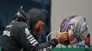 Pembalap Mercedes Lewis Hamilton dari Inggris menangis setelah memenangkan Grand Prix Formula Satu Turki di arena pacuan kuda Istanbul Park di Istanbul, Minggu (15/11/2020). (AP Photo/Kenan Asyali, Pool)