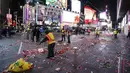 Petugas kebersihan setempat membersihkan sisa-sisa confetti setelah perayaan perayaan tahun baru di Times Square, New York, AS (1/1). (Reuters/ Stephen Yang)