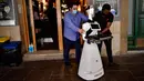 Santo Munoz (kiri) menggerakkan robot yang dikenal sebagai "Alexia" untuk melayani pengunjung sebuah bar di alun-alun Plaza del Castillo, di Pamplona, Spanyol pada 5 Juni 2020. Robot tersebut digunakan untuk mengurangi penyebaran virus corona Covid-19. (AP Photo/Alvaro Barrientos)