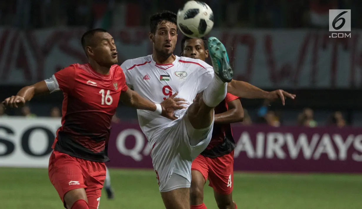 Bek Indonesia, Hansamu Yama berebut bola dengan striker Palestina, Oday Dabbagh pada laga Asian Games di Stadion Patriot, Bekasi, Jawa Barat, Rabu (15/8). Timnas Indonesia U-23 dipaksa menyerah 1-2 oleh Palestina. (Bola.com/Vitalis Yogi Trisna)