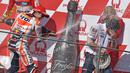Pebalap Repsol Honda Marc Marquez merayakan kemenangan bersama kepala mekanik Honda Carlos Linan (kanan) dengan champagne MotoGP Australian Grand Prix di Phillip Island, (AFP PHOTO/Paul Crock)