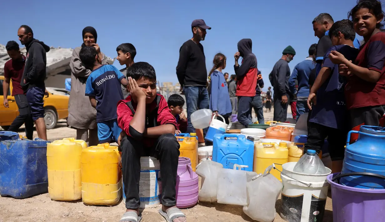 Warga Palestina berusaha mengambil air di sebuah kamp untuk para pengungsi di Kota Gaza, pada tanggal 20 Mei 2025, di tengah perang yang sedang berlangsung antara Israel dan gerakan militan Palestina, Hamas. (Bashar Taleb/AFP)