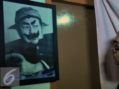 Seorang kerabat memandangi lukisan wajah Almarhum Pak Raden atau Suyadi di rumah duka Petamburan III, Jakarta (30/10/2015). Pak Raden menghembuskan napas terakhirnya di Rumah Sakit Pelni. (Liputan6.com/Faisal R Syam)