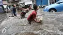 Sejumlah anak bermain banjir di kawasan Kemang Utara, Jakarta Selatan, Rabu (20/7). Banjir yang menggenangi sejumlah kawasan di Jakarta dijadikan kolam renang gratis bagi sejumlah anak. (Liputan6.com/Yoppy Renato)